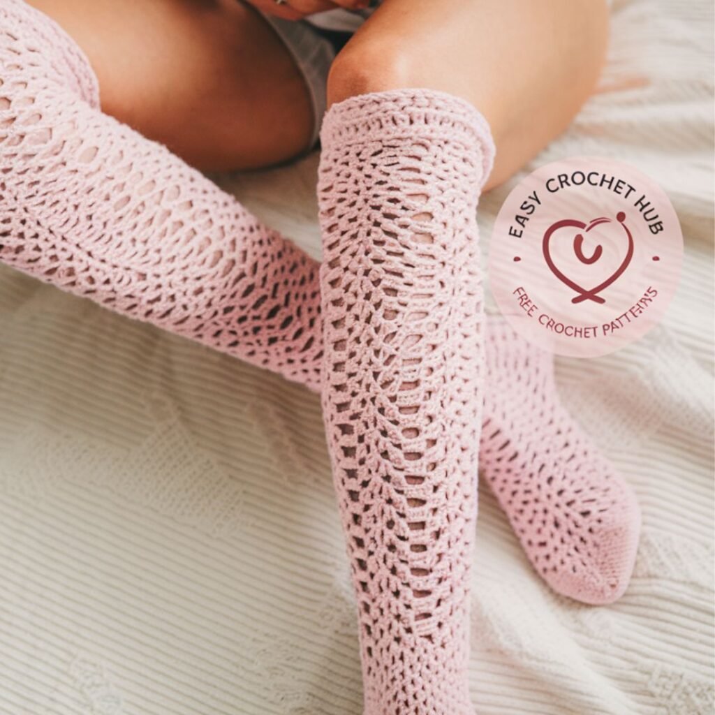 White lacy crochet knee high socks with scalloped edges worn with boots on a rustic wood floor

