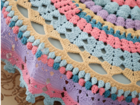 Crochet round tablecloth handmade in cream cotton with intricate lace pattern on a wooden dining table